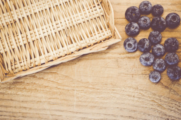 fresh and ripe blackberries in a wicker canister on a natural wood surface