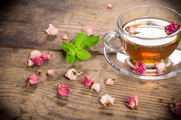 Afwasbaar Fotobehang Thee Cup of green tea with mint and dried roses