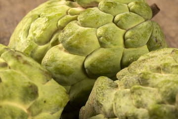 Some Sugar-Apples over a wooden table. Atemóia
