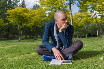 Joven Sentado con un Libro en un Parque