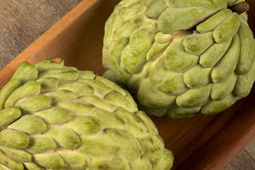 Some Sugar-Apples over a wooden table. Atemóia