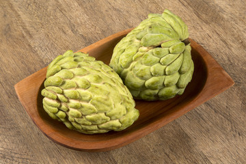 Some Sugar-Apples over a wooden table. Atemóia