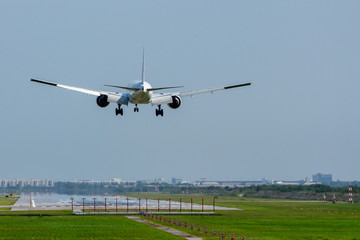 Fototapeta na wymiar Commercial airplane landing on runway in airport