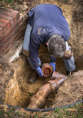 Plumber Working on Old Clay Ceramic Sewer Line Pipes - 87050768