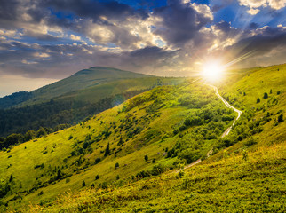 Obraz premium road through hillside in high mountains at sunset