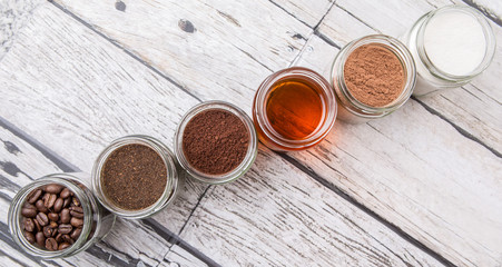 Coffee beans, coffee powder, creamer, cocoa powder, honey and processed tea leaves in a mason jar...
