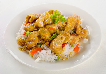 Chicken Curry and rice on a white plate.