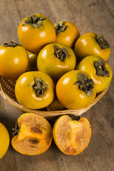 Some khaki fruits over a wooden surface