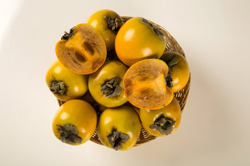 Some khaki fruits over a wooden surface