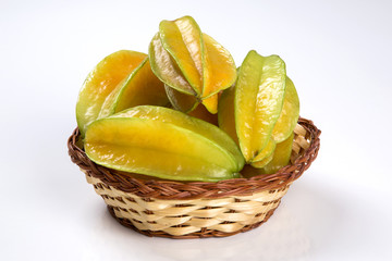Some caramboles in a basket over a wooden surface
