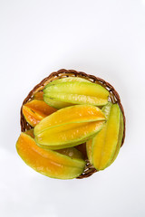 Some caramboles in a basket over a wooden surface