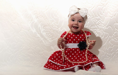 little girl in a red dress and beads