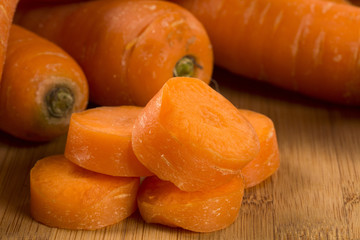 Fresh carrot with green leaves on wooden table