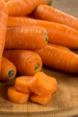Fresh carrot with green leaves on wooden table