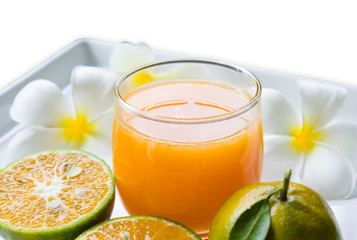 Fototapeta na wymiar a glass of orange juice decorated with fresh orange and flower on white tray and isolate white background