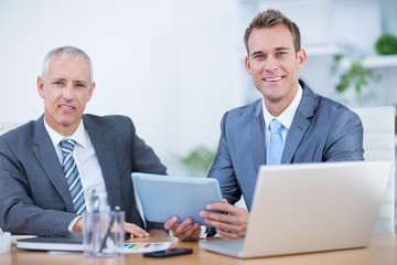 Fototapeta premium Happy businessmen working together on digital tablet