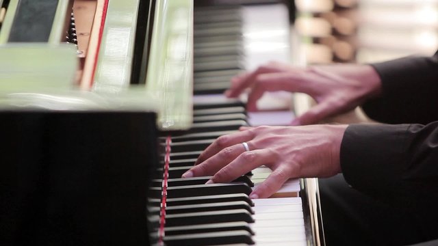 Pianist plays the piano. Pianist's fingers run over the keys. 
