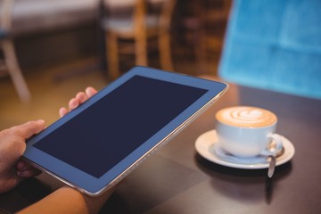  Close-up of digital tablet and coffee on table