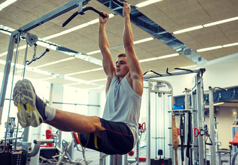 man flexing abdominal muscles on pull-up bar