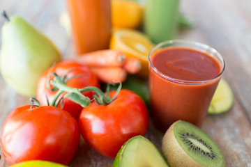close up of fresh juice glass and fruits on table