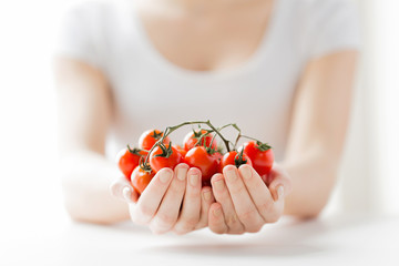 close up of woman hands holding cherry tomatoes