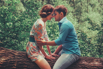 Couple in love sitting on tree in summer