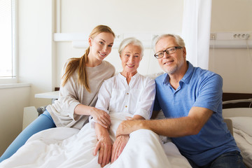 Fototapeta premium happy family visiting senior woman at hospital