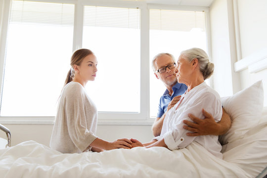 Family Visiting Ill Senior Woman At Hospital