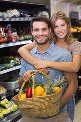 Portrait of smiling bright couple buying vegetables 