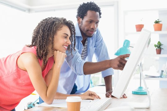 Two creative business colleagues watching the computer