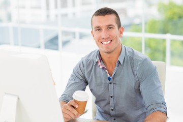 Smiling creative businessman holding a mug of coffee