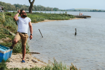 American Bearded Man using phone near the river