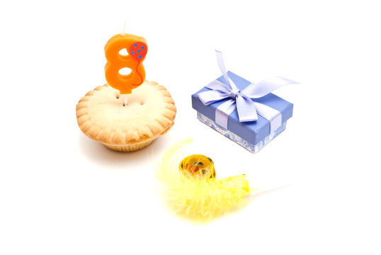 cupcake with eight years birthday candle, gift and whistle on wh