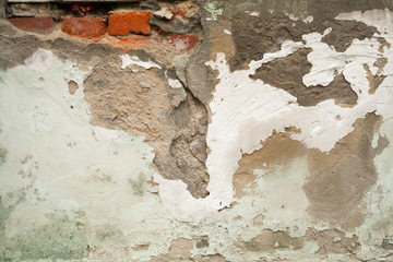 Grunge aged empty street wall of the old house with cracks, plaster falling off
