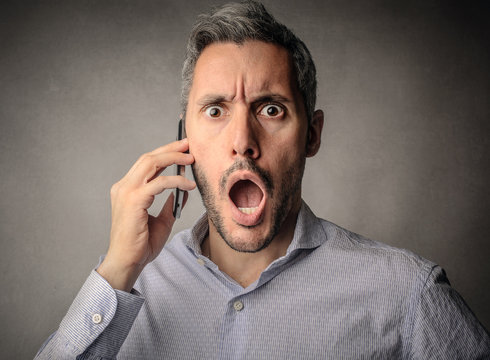 Surprised businessman doing a phone call