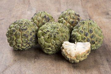 Some Sugar-Apples over a wooden surface.