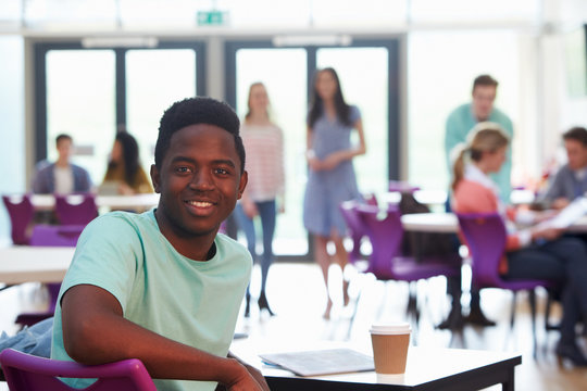 Portrait Of Male College Student Relaxing In Cafeteria