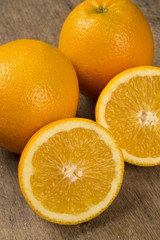 Close up of some oranges in a basket over a wooden surface