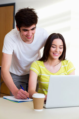 Male And Female College Student Using Laptop In Classroom