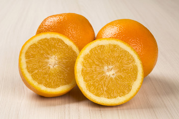 Close up of some oranges in a basket over a wooden surface