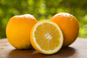 Close up of some oranges in a basket over a wooden surface
