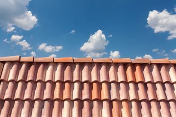 Red roof tile pattern over blue sky