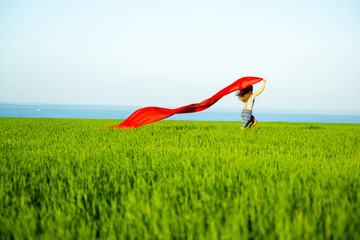 Young happy woman in wheat field with fabric. Summer lifestyle