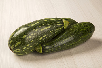 Some zucchinis over a white wooden surface