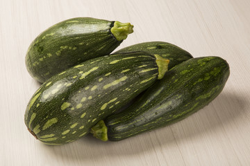 Some zucchinis over a white wooden surface