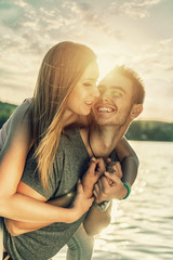 Couple in love embracing at the lake, sun flare