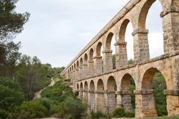 Fototapeta na wymiar Devil’s bridge Roman aqueduct built near Tarragona, Catalonia, Spain, wearing the river Francoli in the ancient city of Tarraco. One of the most monumental aqueducts and best preserved Roman times.