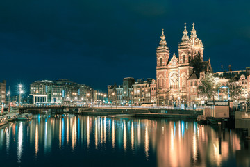 Fototapeta na wymiar Night Amsterdam canal and Basilica Saint Nicholas