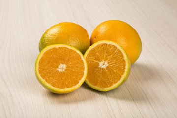 Close up of some oranges in a basket over a wooden surface