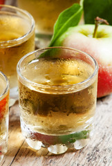 Cold apple juice and fresh apples on an old wooden table, select